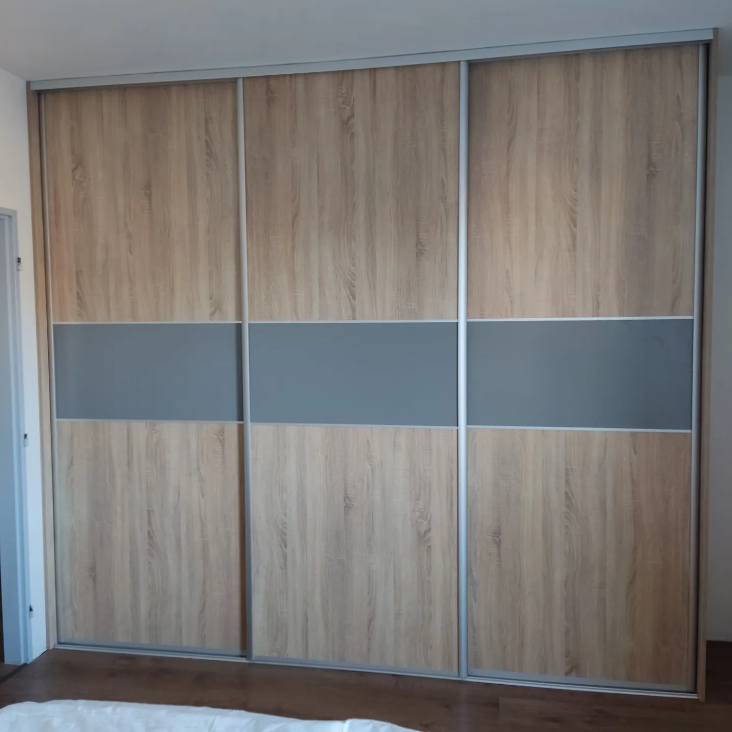 Vstavaná skriňa na mieru s posuvnými dverami a elegantným kombinovaným dekorom z dreva