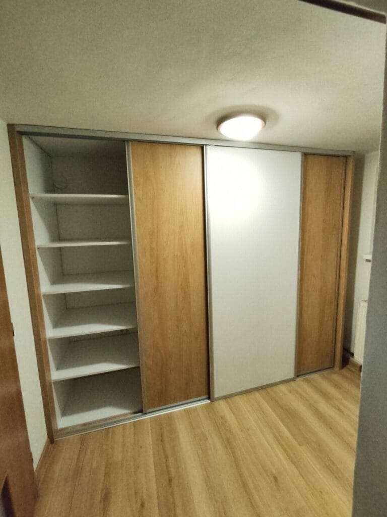Vstavaná skriňa na mieru s posuvnými dverami a elegantným kombinovaným dekorom z dreva